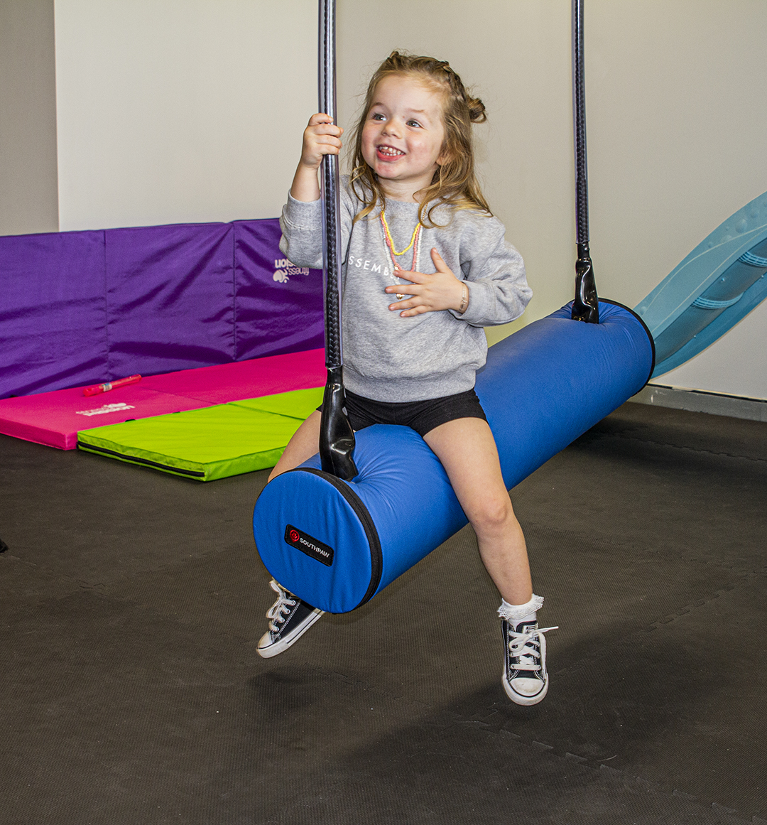 Child on a bolster swing in an Occupational Therapy clinic with an Occupational Therapist for developmental delay or autism in Bondi Junction and Mascot in Sydney